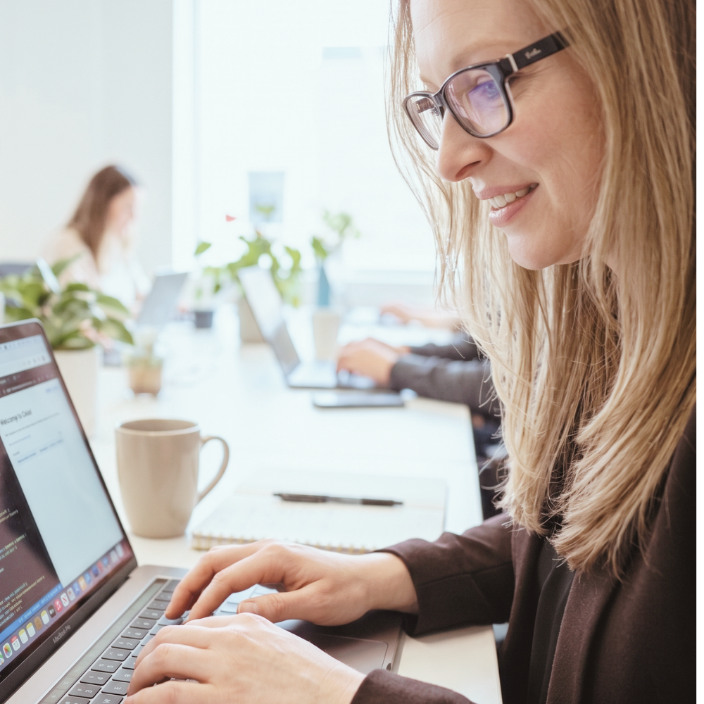 Image of Pam writing content on her laptop